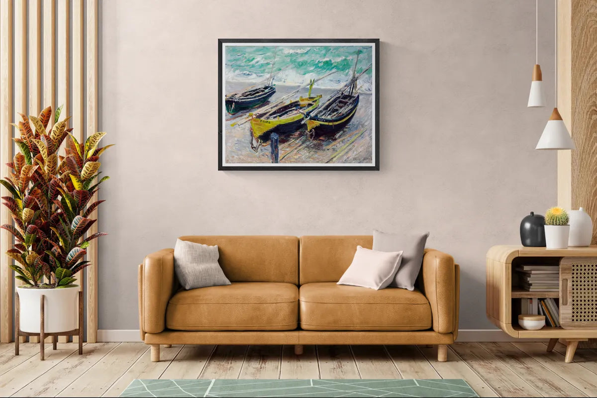 Claude Monet's Three Fishing Boats framed in black above a tan leather sofa