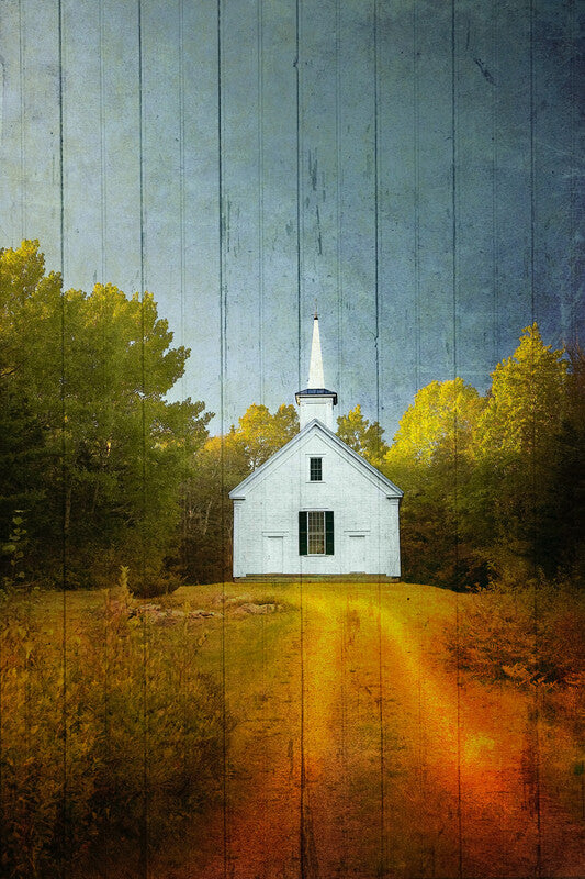 A white chapel with a steeple stands in a field surrounded by golden trees against a blue wooden plank background.