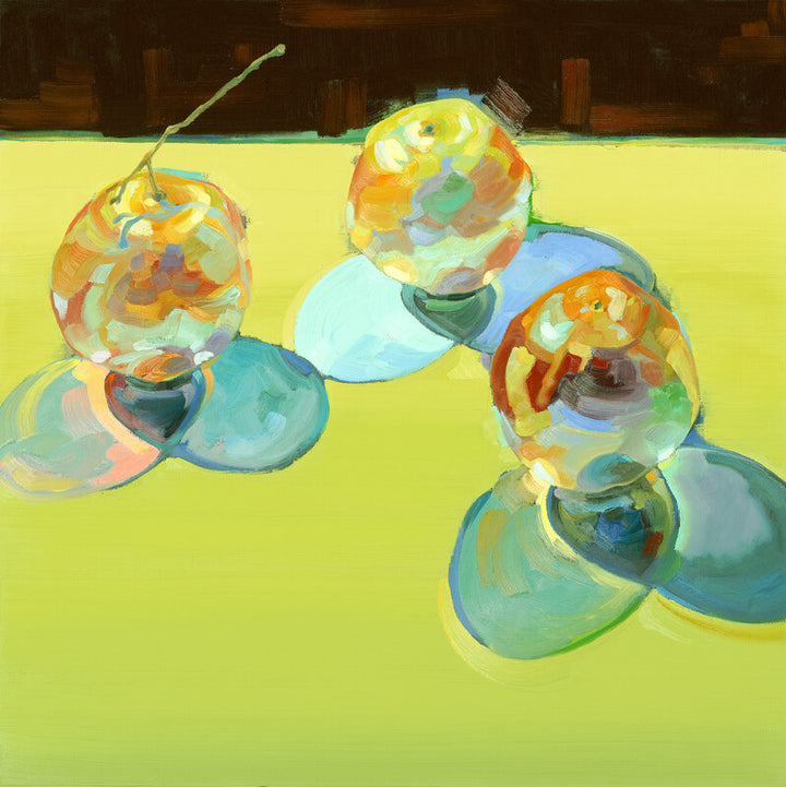 Three colorful spherical fruits with stems arranged on a bright yellow background against a dark wooden structure.