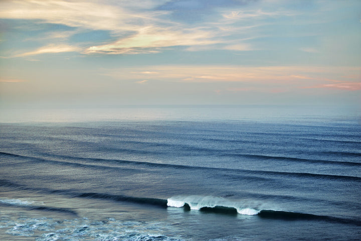 Serene seascape with layered waves, soft horizon line, and pastel sky in blues and cream tones.