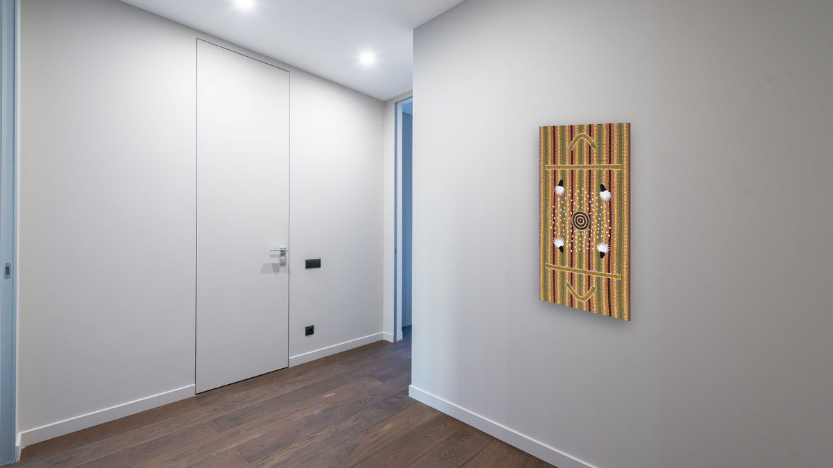 Men's Dreaming by Clifford Possum Tjapaltjarri, shown at 20 × 40 in (50.8 × 101.6 cm) as gallery-wrapped canvas, hallway