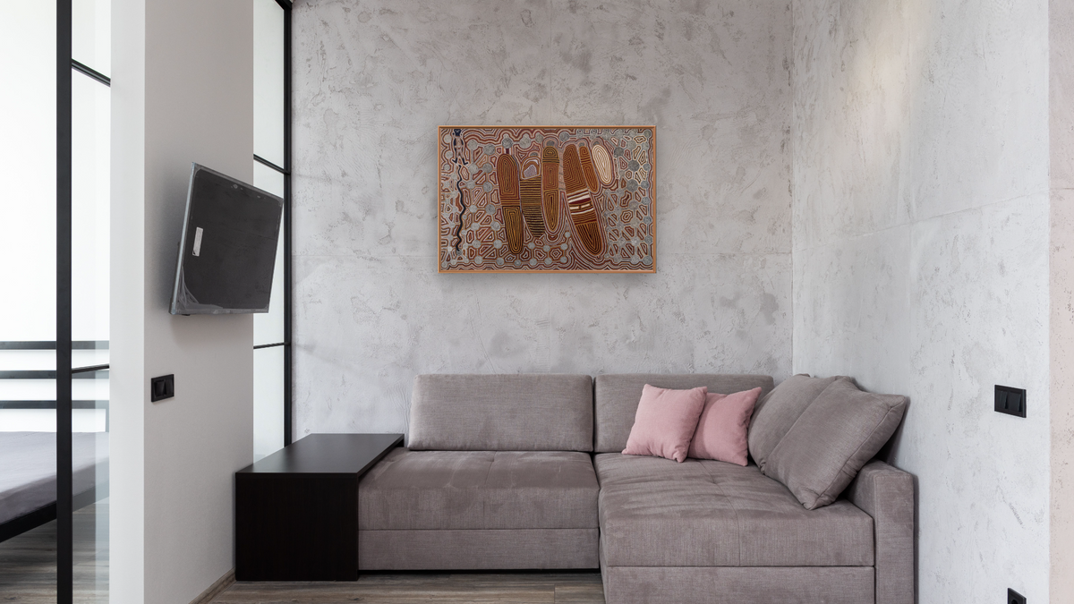 Old Man's Dreaming by Uta Uta Tjangala, shown at 28 × 42 in (71.1 × 106.7 cm) on canvas in Arber Raw Oak, media room