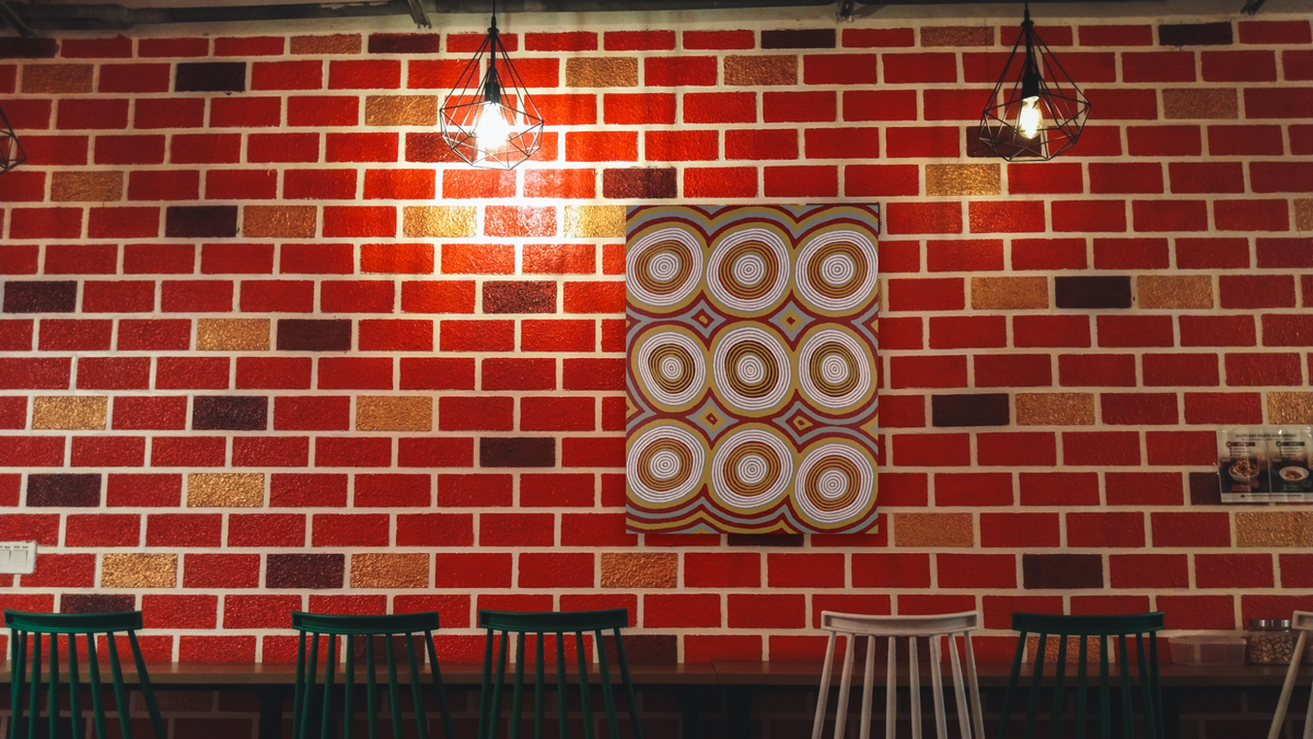 Dream of Two Women by Ronnie Tjampitjinpa, shown at 32 × 40 in (81.3 × 101.6 cm) as gallery-wrapped canvas, restaurant