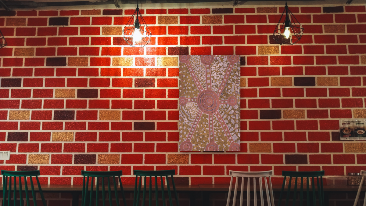 Water Dreaming by Long Jack Phillipus Tjakamarra, shown at 28 × 42 in (71.1 × 106.7 cm) as gallery-wrapped canvas, restaurant