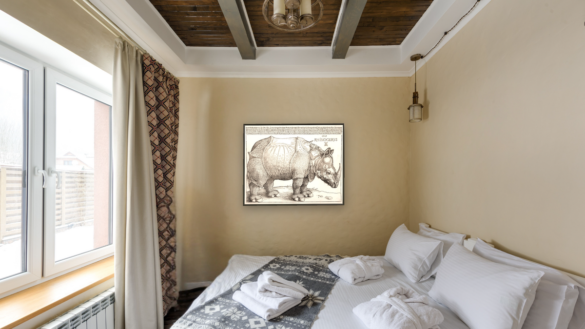The Rhinoceros by Albrecht Dürer, shown at 32 × 40 in (81.3 × 101.6 cm) on canvas in Ramino Satin Black, hotel guest room