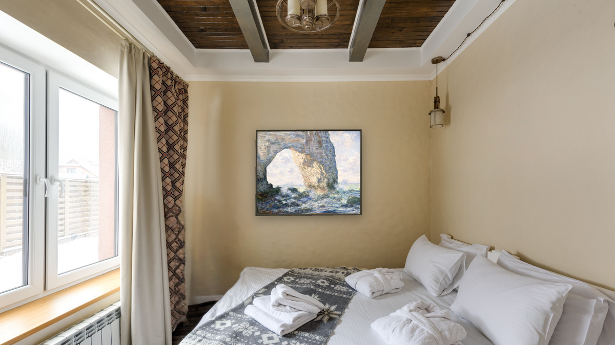 The Manneporte (Etretat) by Claude Monet, shown at 32 × 40 in (81.3 × 101.6 cm) on canvas in Ramino Satin Black, hotel guest room