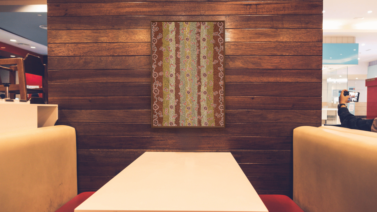 Flying Ant Dreaming by Clifford Possum Tjapaltjarri, shown at 28 × 42 in (71.1 × 106.7 cm) on canvas in Arber Warm Walnut, restaurant