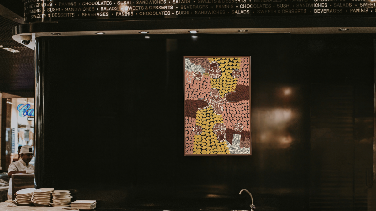 Untitled by Billy Stockman Tjapaltjarri, shown at 28 × 42 in (71.1 × 106.7 cm) on canvas in Arber Warm Walnut, restaurant