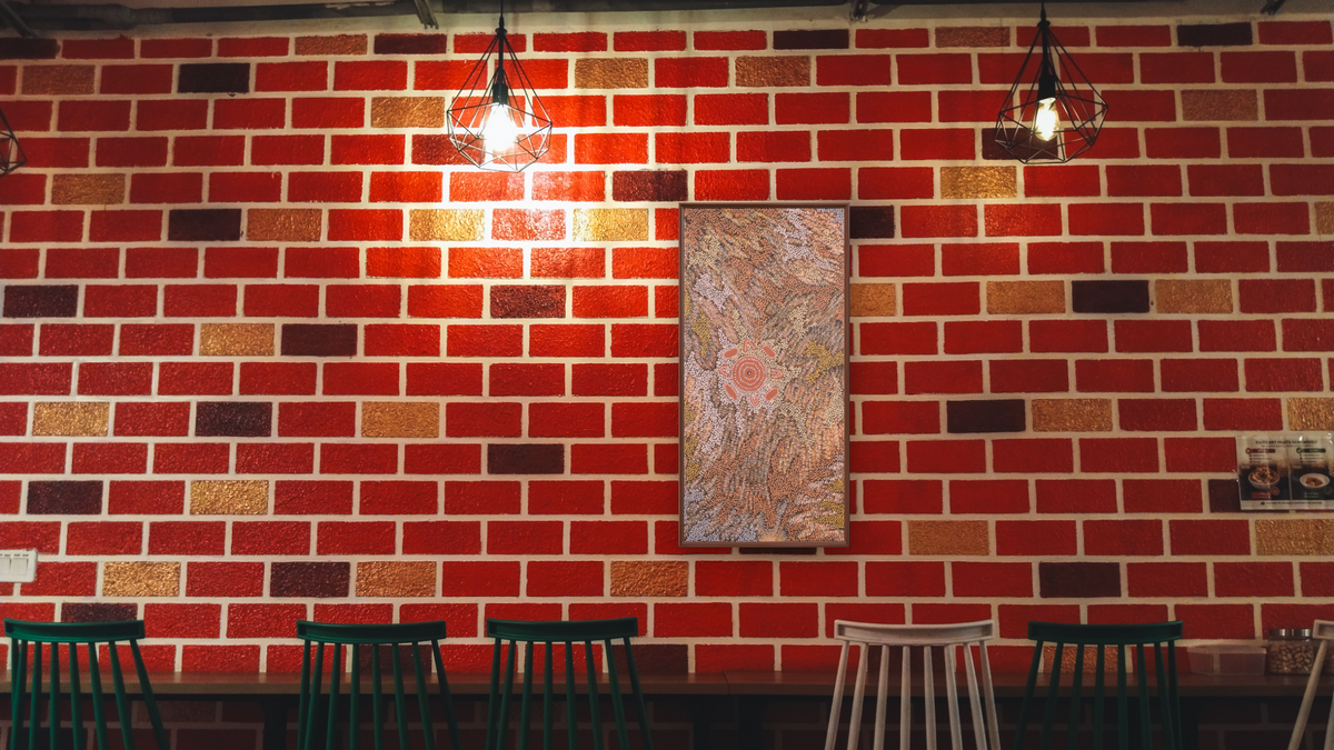 Women's Dreaming by Maxie Tjamitjinpa, shown at 20 × 40 in (50.8 × 101.6 cm) on canvas in Arber Warm Walnut, restaurant
