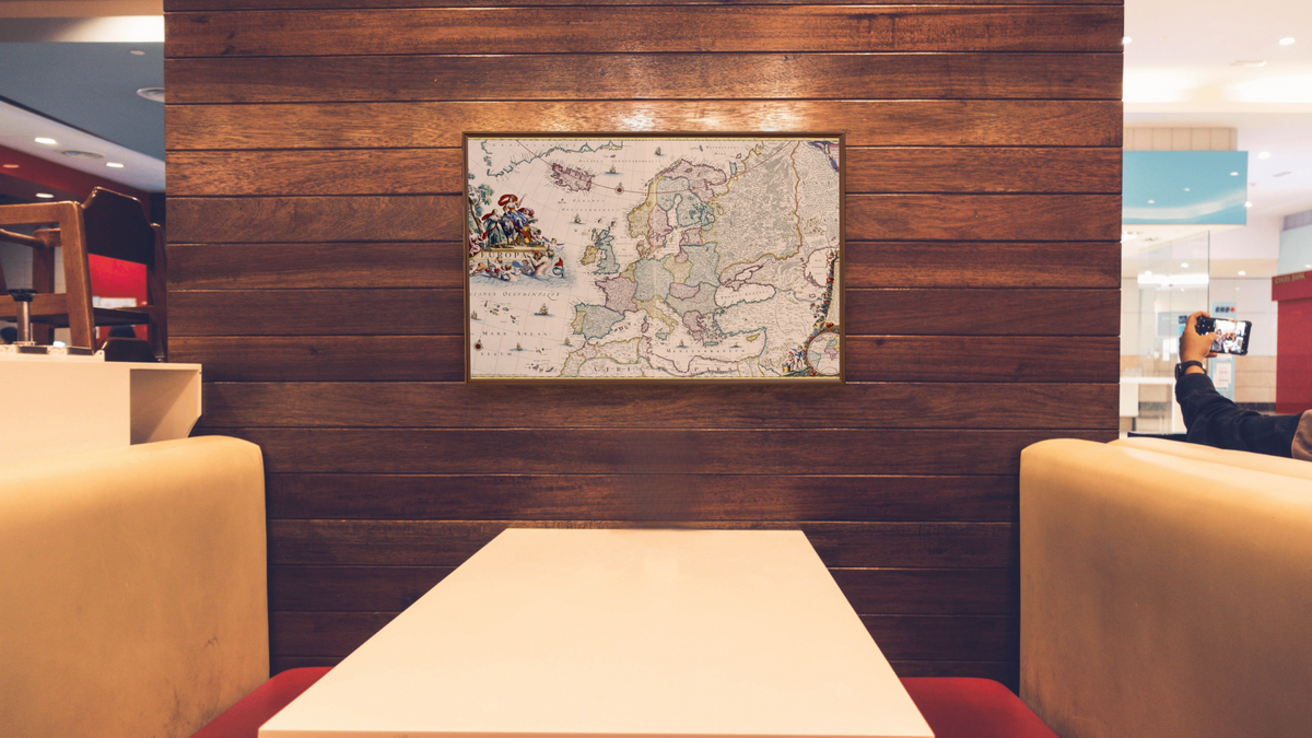 Map of Europe by Cornelis Danckerts, shown at 28 × 42 in (71.1 × 106.7 cm) on canvas in Arber Warm Walnut, restaurant
