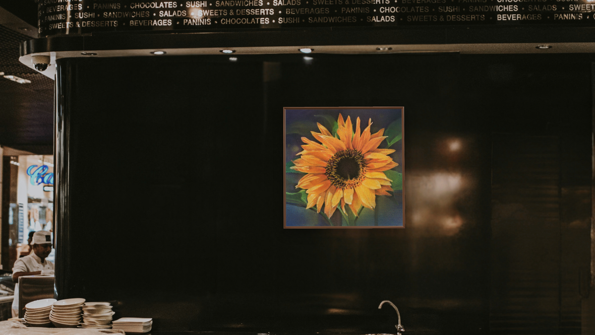 Single Sunflower by Kirsten Söderlind, shown at 32 × 32 in (81.3 × 81.3 cm) on canvas in Arber Warm Walnut, restaurant