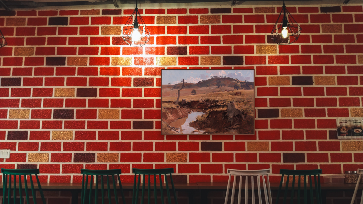 The Creek by Arthur Streeton, shown at 28 × 42 in (71.1 × 106.7 cm) on canvas in Arber Warm Walnut, restaurant