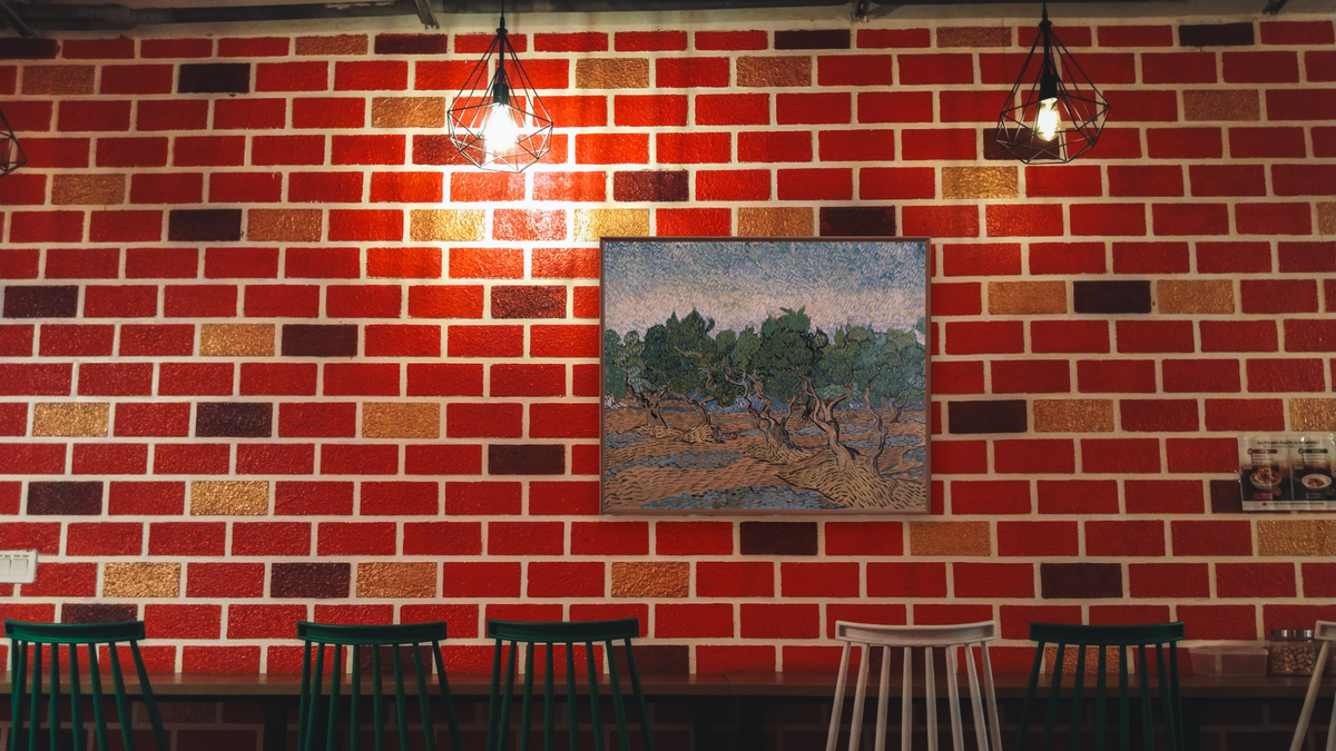 Olive grove by Vincent van Gogh, shown at 32 × 40 in (81.3 × 101.6 cm) on canvas in Arber Warm Walnut, restaurant