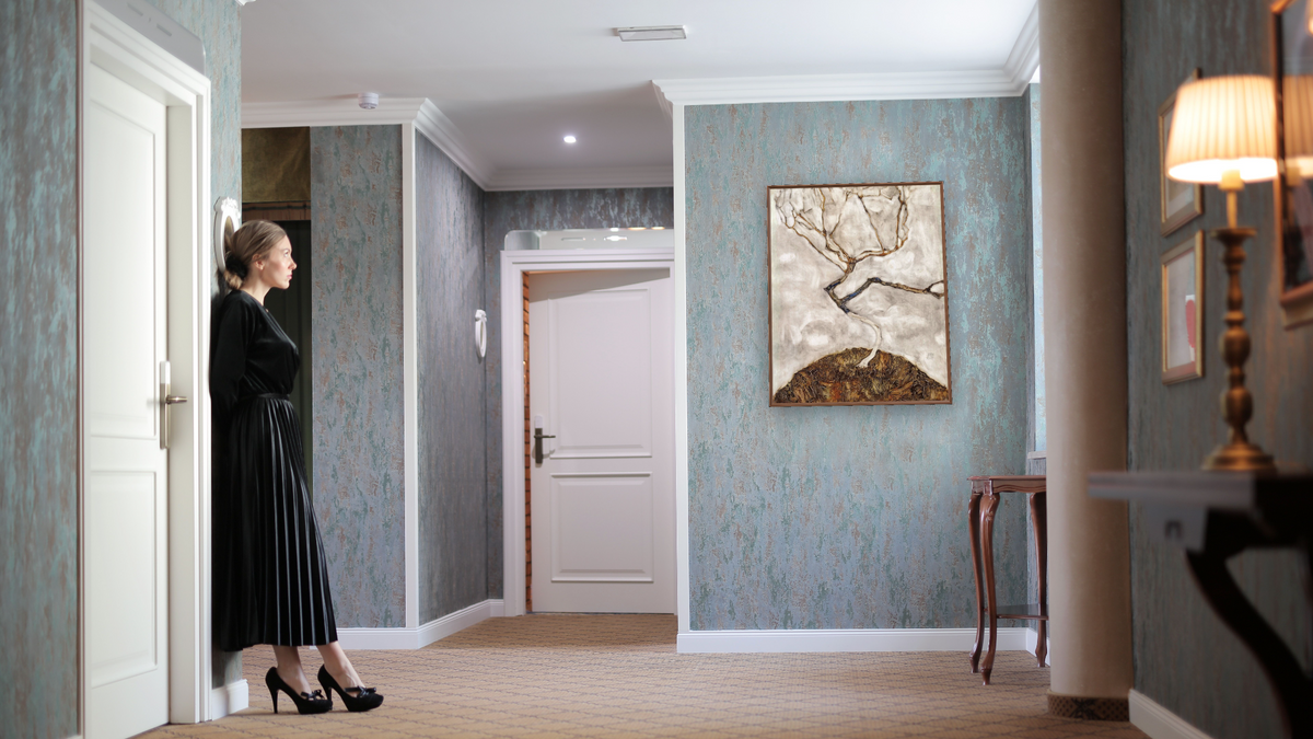 Small Tree in Late Autumn by Egon Schiele, shown at 32 × 40 in (81.3 × 101.6 cm) on canvas in Arber Warm Walnut, hotel lobby