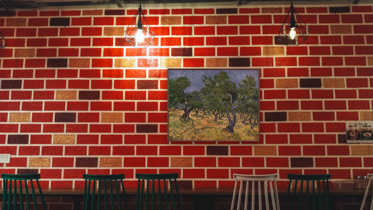 Olive Orchard by Vincent van Gogh, shown at 30 × 40 in (76.2 × 101.6 cm) on canvas in Arber Warm Walnut, restaurant