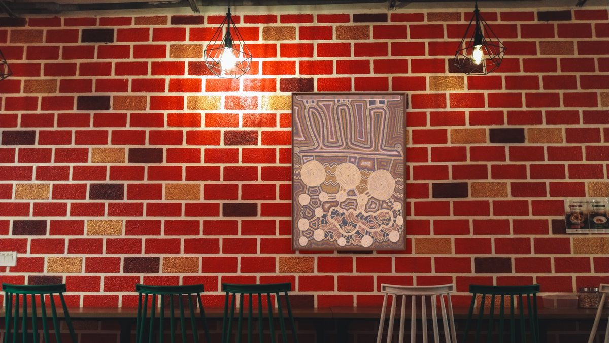 Untitled by Uta Uta Tjangala, shown at 30 × 40 in (76.2 × 101.6 cm) on canvas in Arber Warm Walnut, restaurant