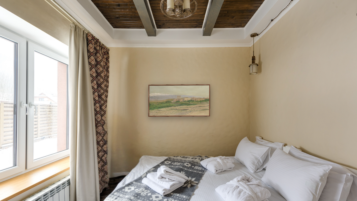 View of Baalbek by Frederic Edwin Church, shown at 20 × 40 in (50.8 × 101.6 cm) on canvas in Arber Warm Walnut, hotel guest room
