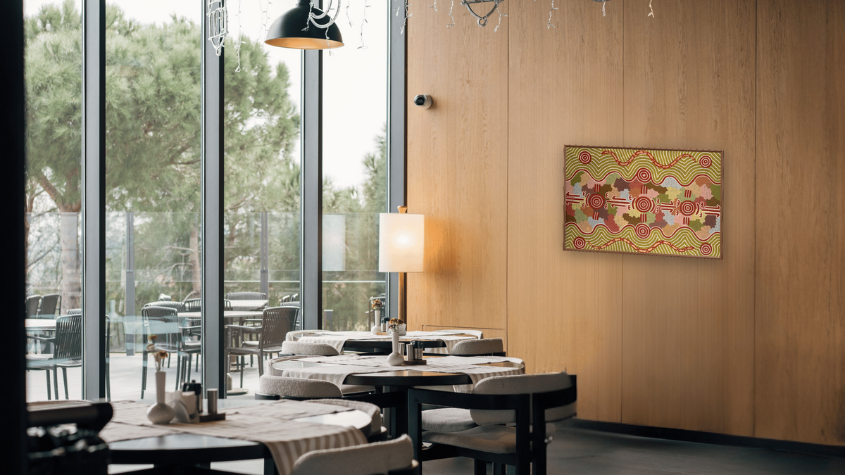 Kangaroo Dreaming with Rainbow Serpent by Michael Nelson Tjakamarra, shown at 28 × 42 in (71.1 × 106.7 cm) on canvas in Arber Warm Walnut, restaurant