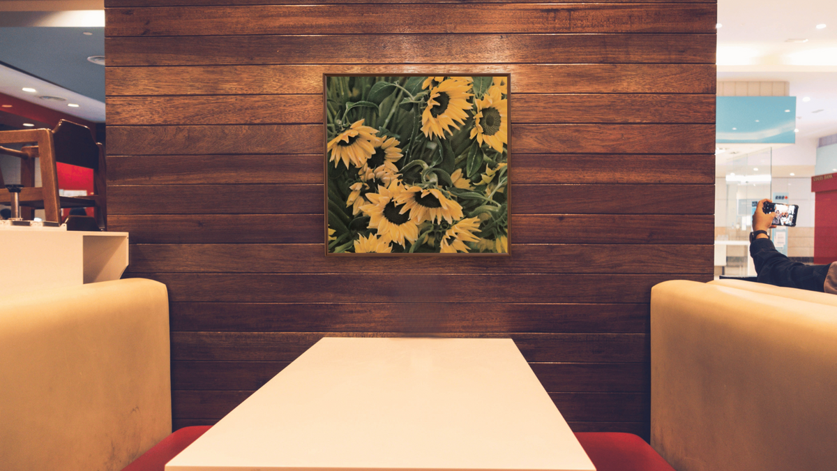 Sunflowers by Kirsten Söderlind, shown at 32 × 32 in (81.3 × 81.3 cm) on canvas in Arber Warm Walnut, restaurant