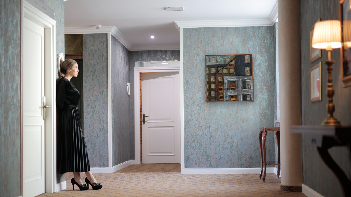 Casting Doubt by Dobee Snowber, shown at 32 × 32 in (81.3 × 81.3 cm) on canvas in Arber Warm Walnut, hotel lobby