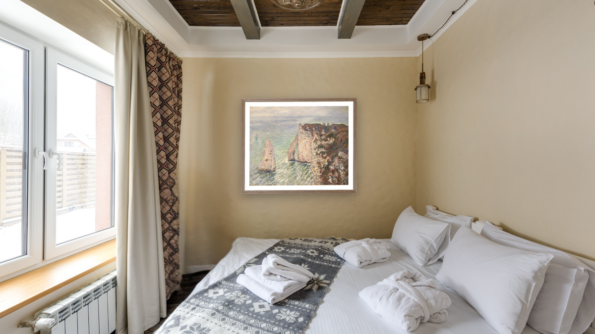 L'Aiguille and the Porte d'Eval, Etretat by Claude Monet, shown at 32 × 40 in (81.3 × 101.6 cm) in Arber Light Walnut, hotel guest room
