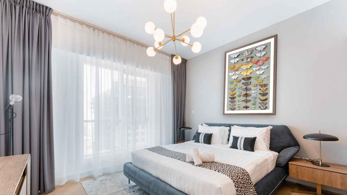 Sixty-three Moths, arranged inthree or five irregular columns by Marian Ellis Rowan, shown at 28 × 42 in (71.1 × 106.7 cm) in Arber Light Walnut, hotel guest room